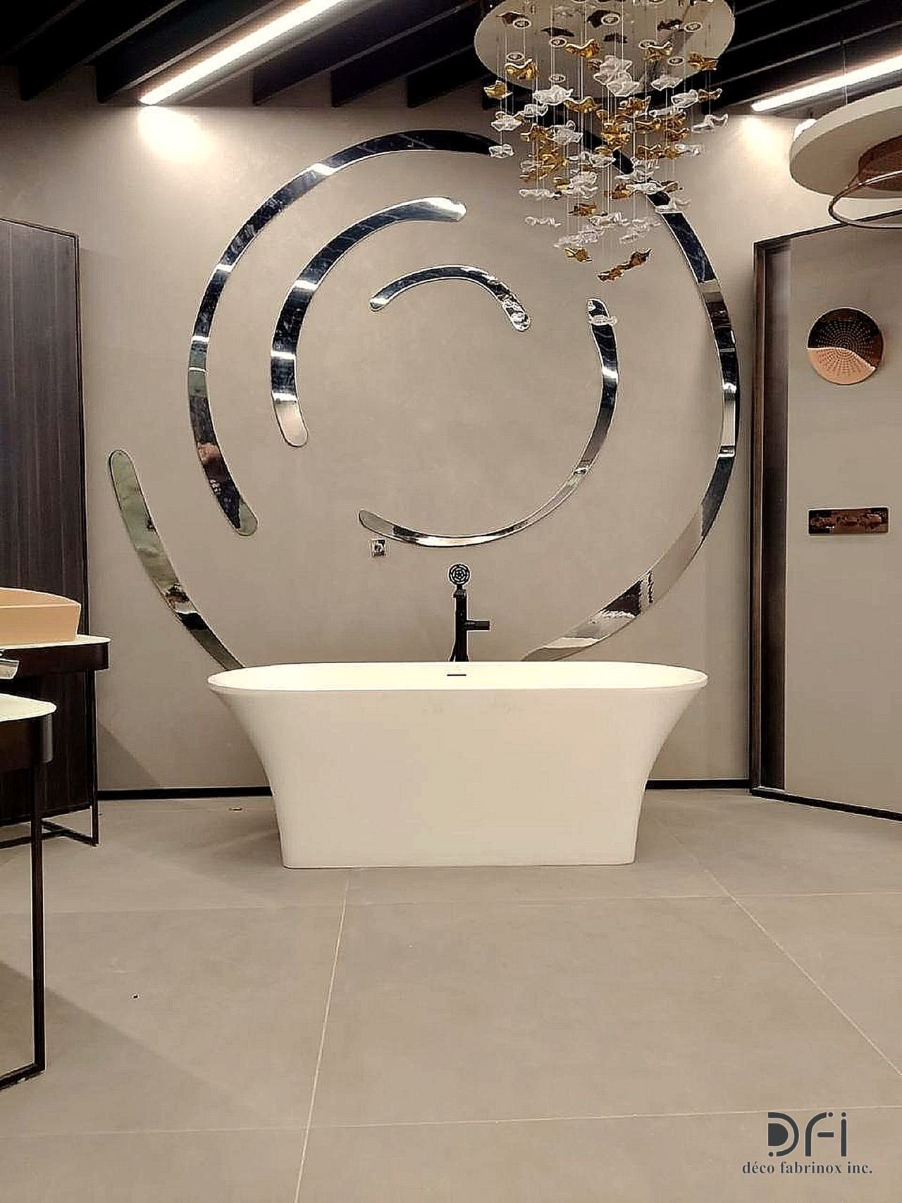 Spa bath before a spiral mirror-steel wall sculpture