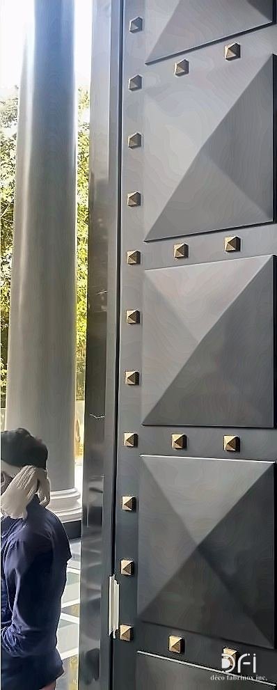 Studded faceted metal entrance door panel