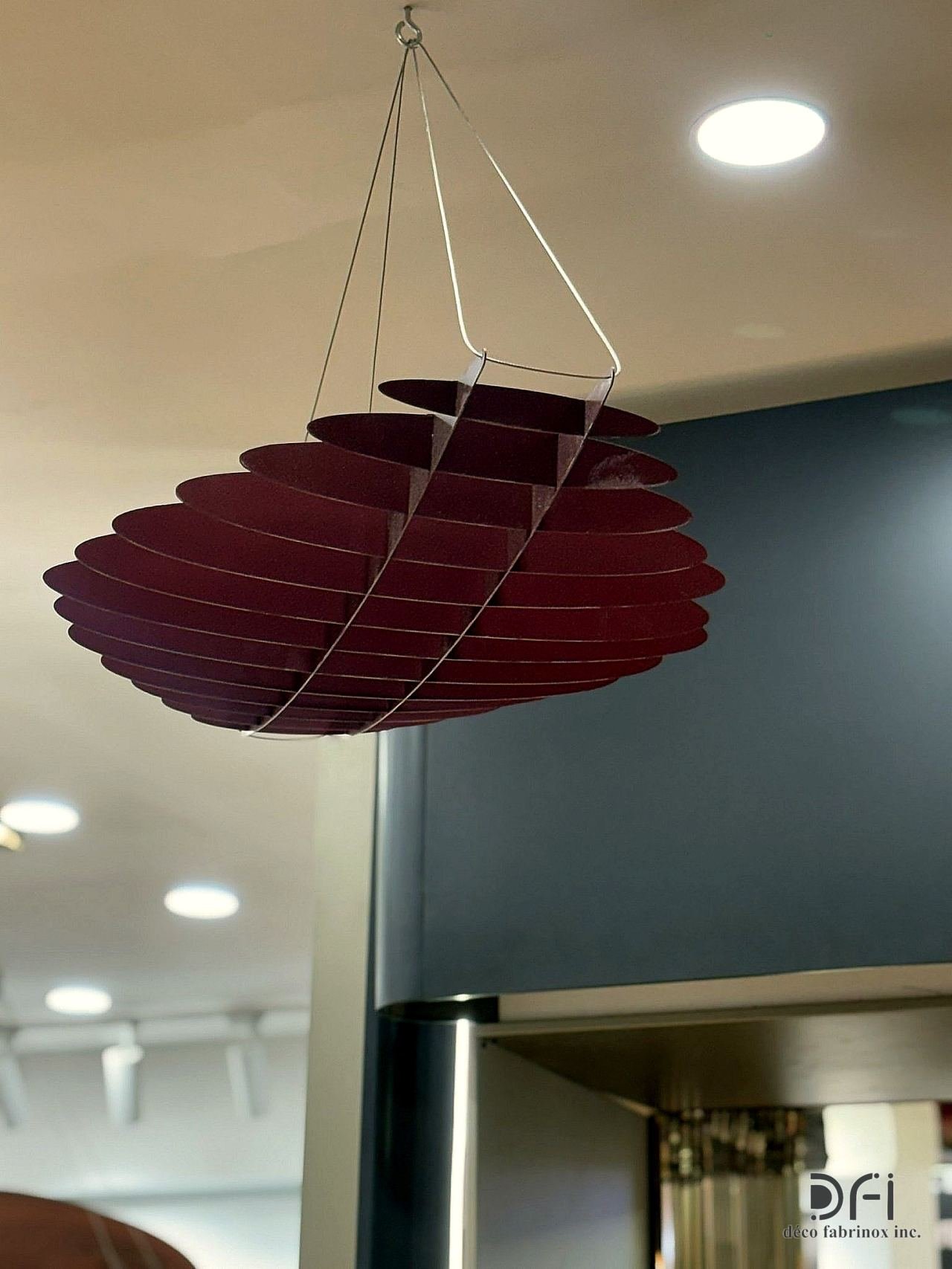 Suspended sculptural metal fin feature hanging from a ceiling