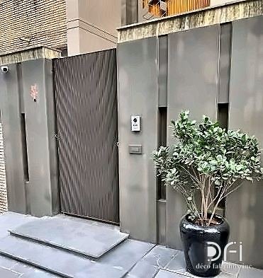 Textured metal gate set into a boundary wall