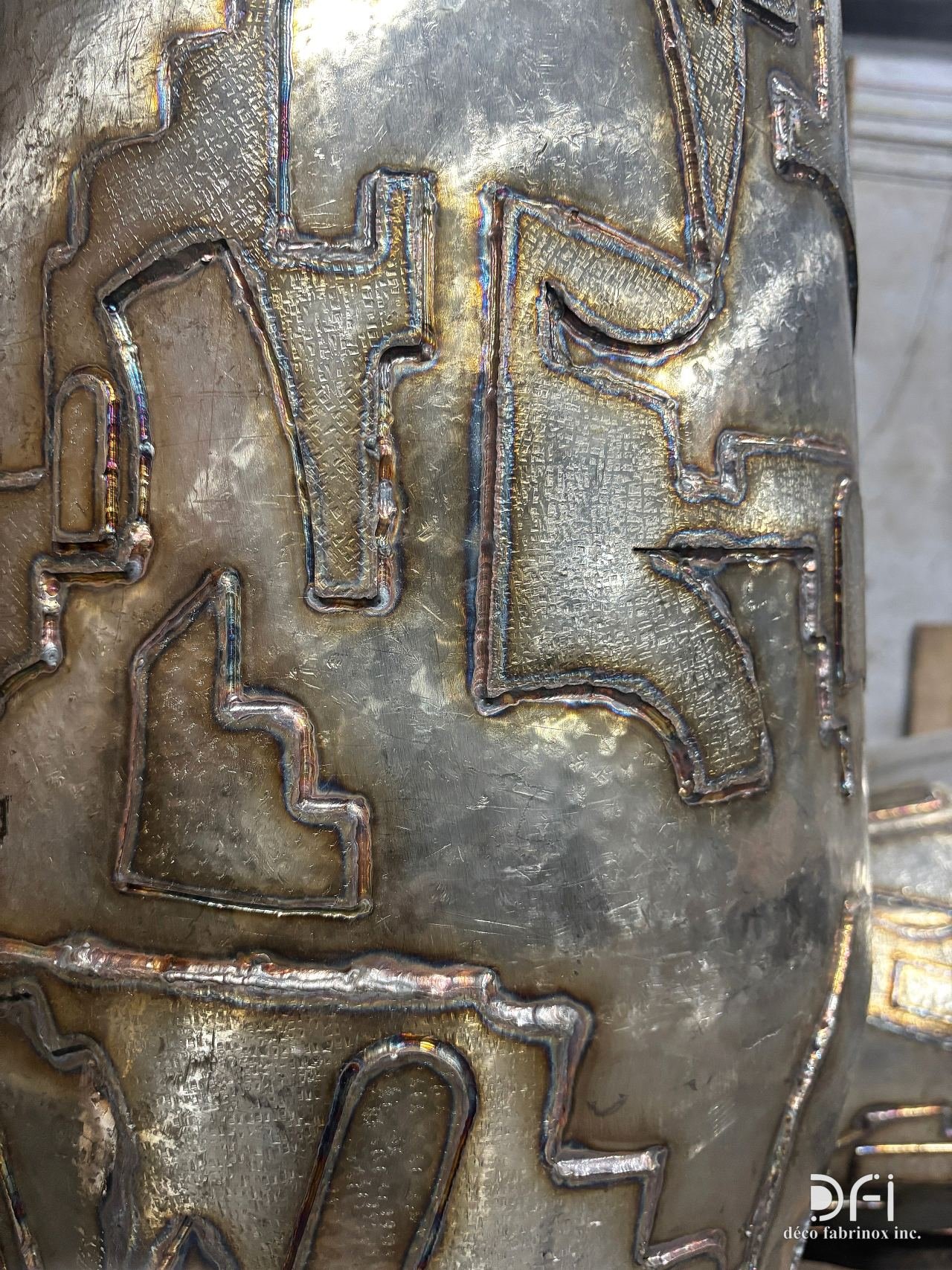 Close view of hand-welded relief on a metal vase