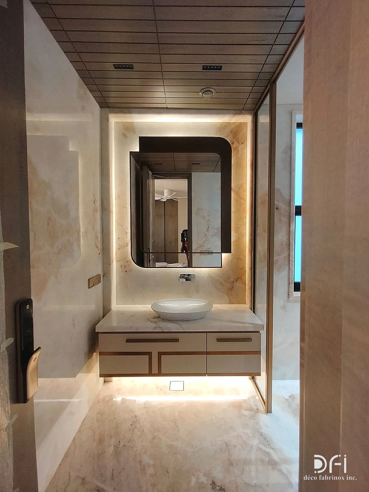Washroom vanity with metal trims and a backlit mirror